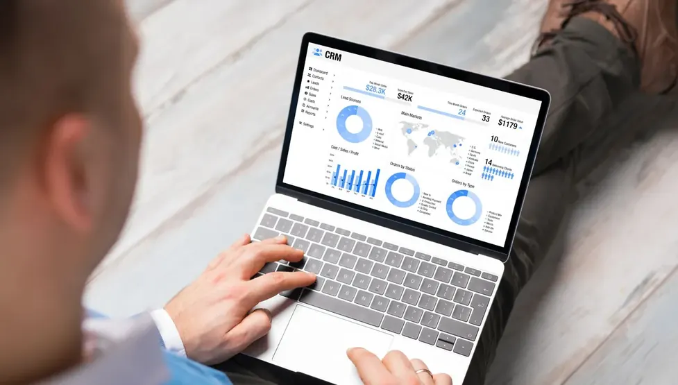 Mãos operando notebook que exibe gráficos de desempenho